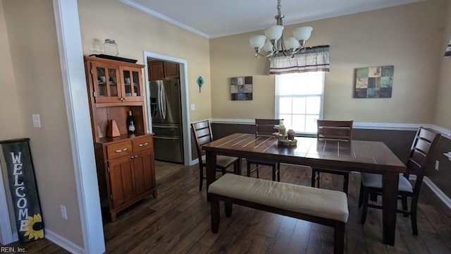 dining room featuring dark wood-style floors, baseboards, ornamental molding, and an inviting chandelier