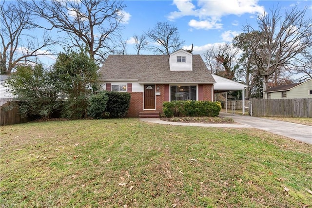 view of front of house featuring brick siding, a shingled roof, a front yard, fence, and driveway