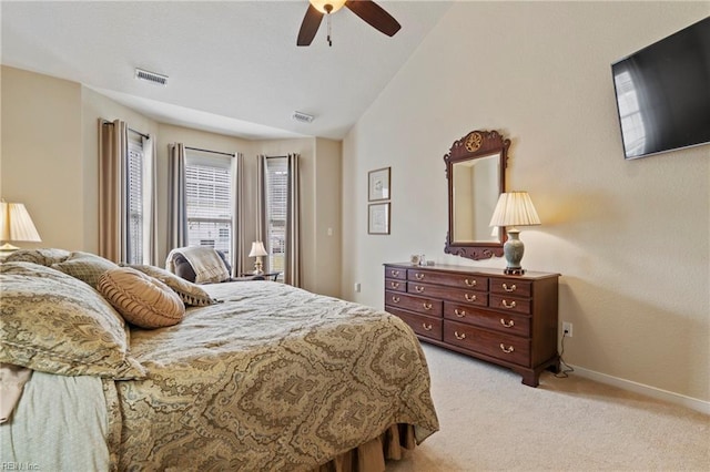 bedroom with lofted ceiling, light carpet, visible vents, and baseboards