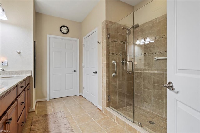 bathroom featuring a shower stall, vanity, baseboards, and tile patterned floors