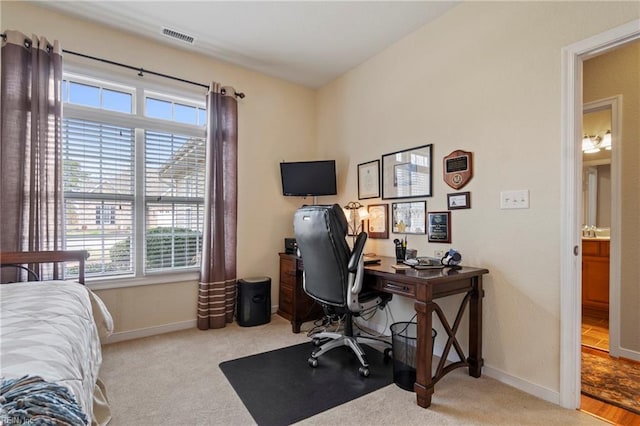 office space with carpet floors, visible vents, and baseboards