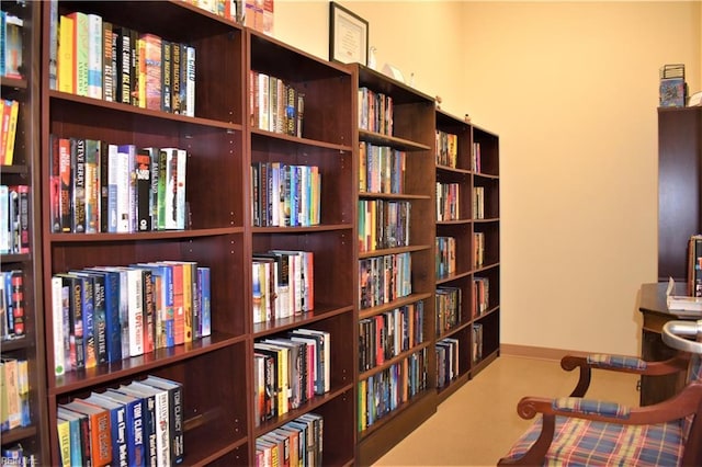 sitting room with wall of books and baseboards