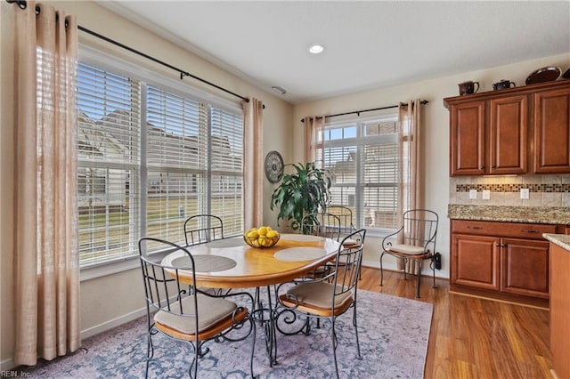 dining space featuring baseboards and light wood-style floors