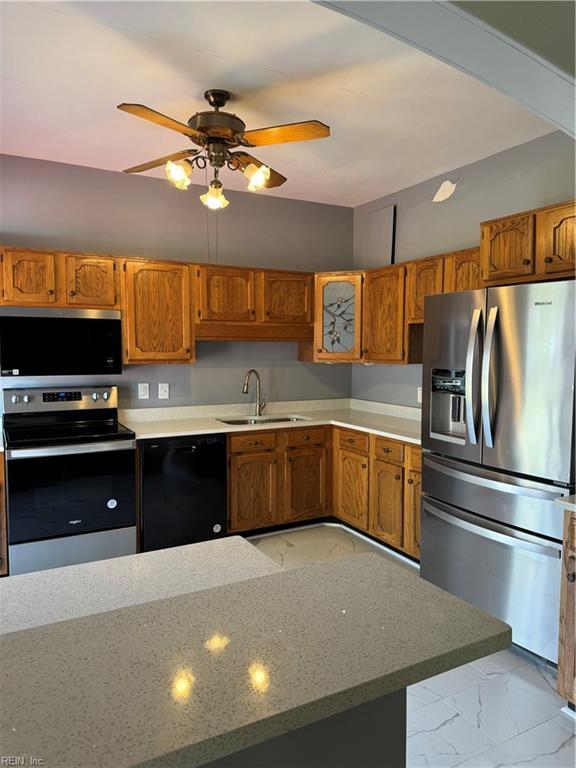 kitchen featuring appliances with stainless steel finishes, brown cabinetry, and a sink