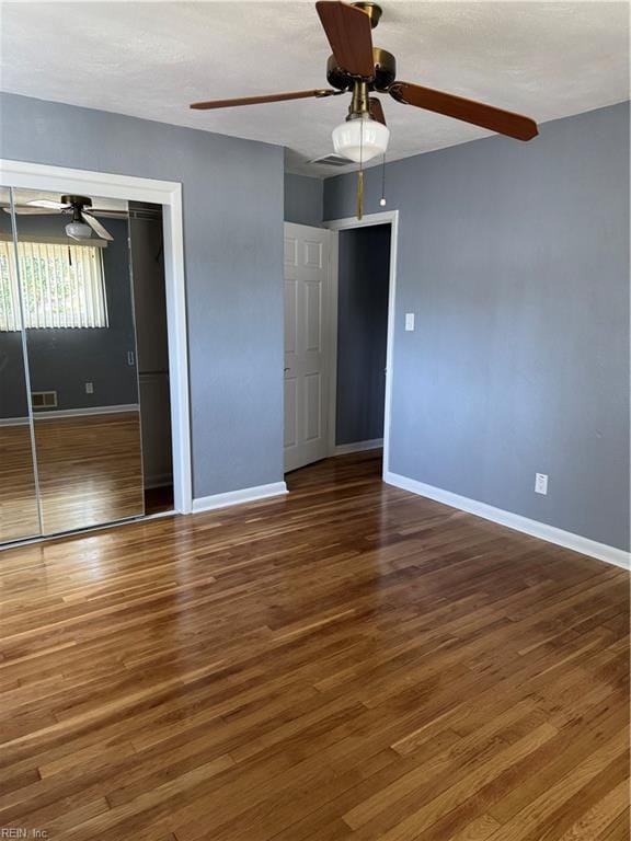 unfurnished bedroom featuring a closet, baseboards, and wood finished floors