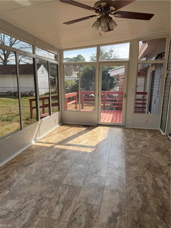 unfurnished sunroom featuring a ceiling fan