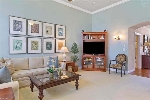 living area with arched walkways, baseboards, crown molding, and carpet