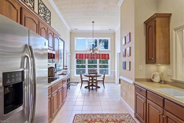 kitchen featuring light tile patterned floors, light countertops, appliances with stainless steel finishes, crown molding, and brown cabinets