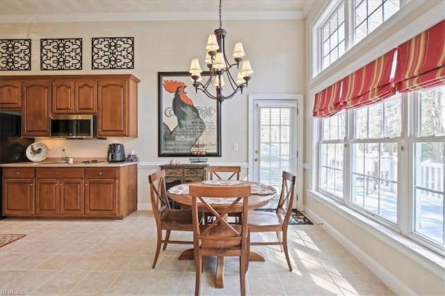 dining space featuring a wealth of natural light, baseboards, a chandelier, and ornamental molding