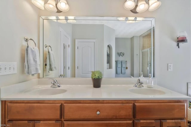 full bath with double vanity, a shower stall, and a sink