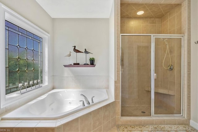 full bath featuring a jetted tub and a shower stall