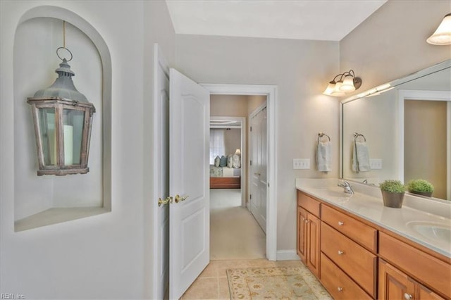 bathroom featuring a sink, double vanity, tile patterned floors, and connected bathroom