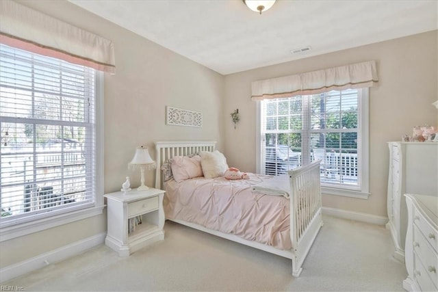 bedroom with visible vents, baseboards, and light carpet