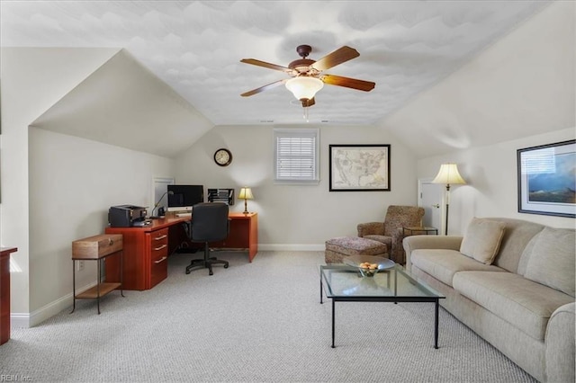 carpeted office space featuring vaulted ceiling, a ceiling fan, and baseboards