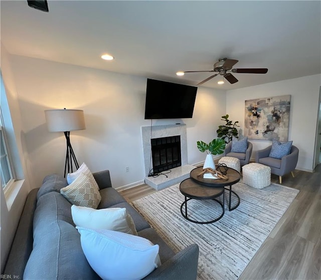 living room with recessed lighting, baseboards, wood finished floors, and a high end fireplace