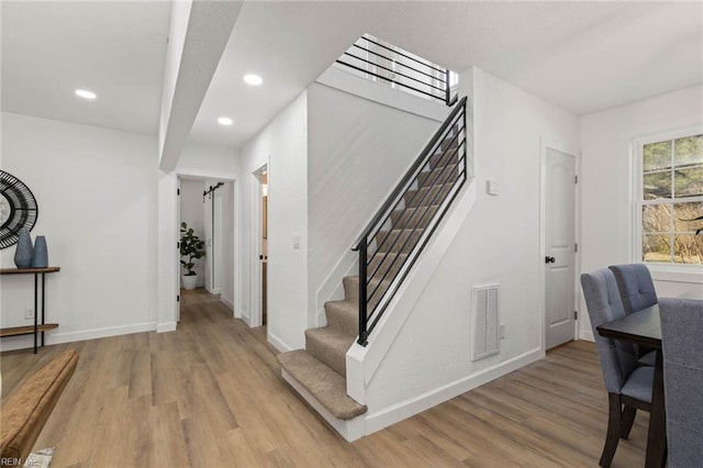 stairs featuring visible vents, baseboards, and wood finished floors