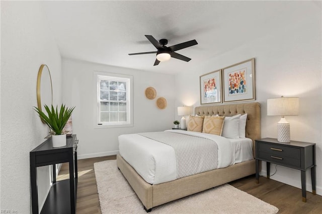 bedroom with dark wood-type flooring, ceiling fan, and baseboards