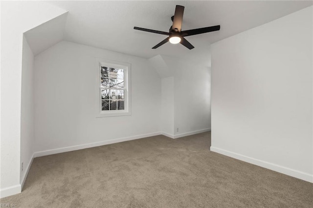 additional living space featuring carpet, baseboards, vaulted ceiling, and a ceiling fan