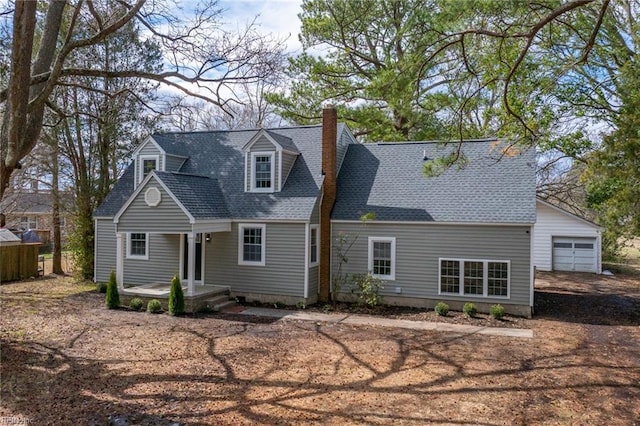 view of front of property featuring a garage, roof with shingles, and a chimney