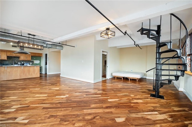 living area featuring stairs, baseboards, and wood finished floors