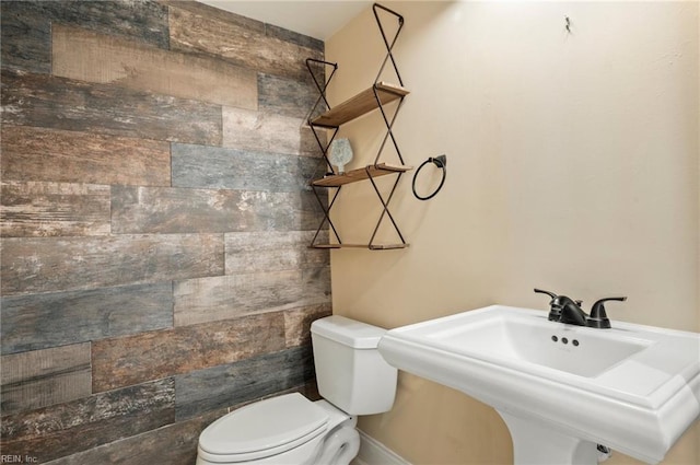 bathroom with a sink, a tile shower, and toilet