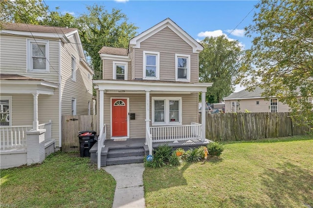 view of front of property with covered porch, a front lawn, and fence