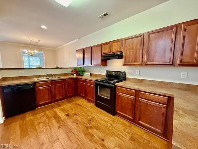 kitchen featuring light wood finished floors, a sink, black appliances, under cabinet range hood, and crown molding