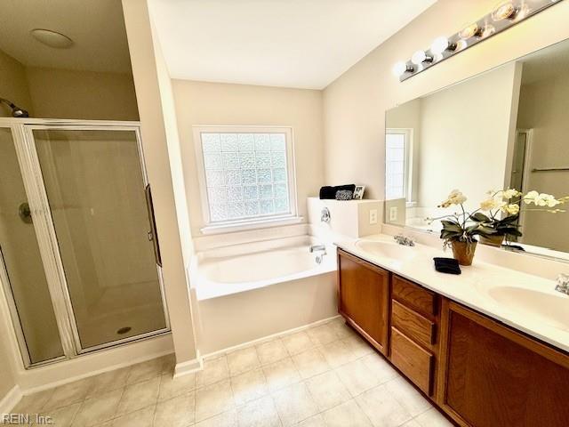 full bath with a shower stall, a garden tub, and a sink