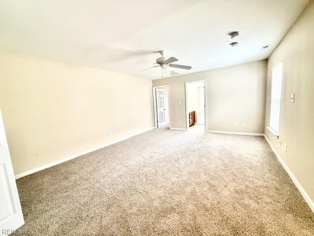 unfurnished room with a ceiling fan, light colored carpet, and baseboards