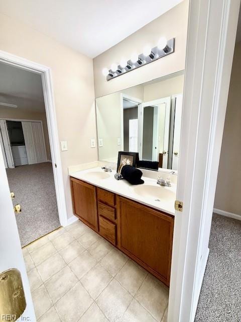 bathroom featuring double vanity, tile patterned floors, baseboards, and a sink