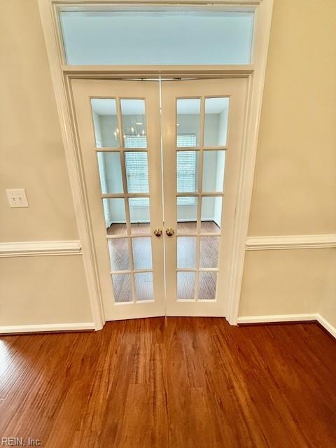 doorway to outside with french doors, baseboards, and wood finished floors