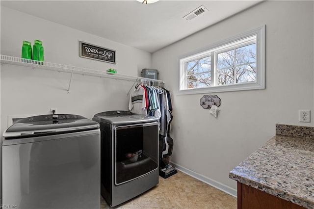 laundry area with washing machine and clothes dryer, laundry area, baseboards, and visible vents