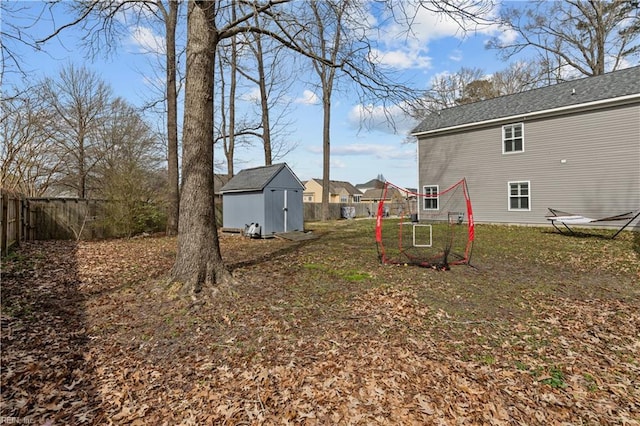 view of yard with an outbuilding, a storage unit, and a fenced backyard