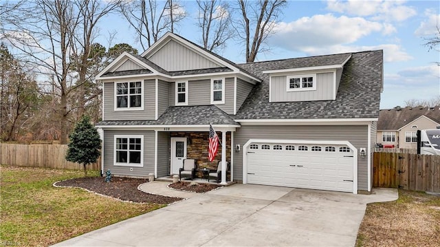 traditional-style home with roof with shingles, concrete driveway, and fence