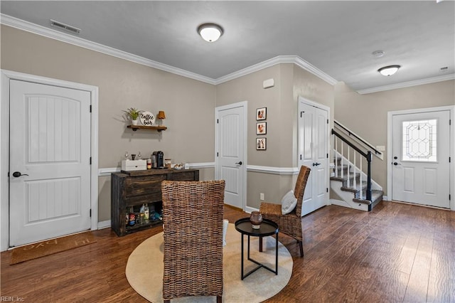 foyer entrance with baseboards, visible vents, dark wood-style flooring, ornamental molding, and stairs