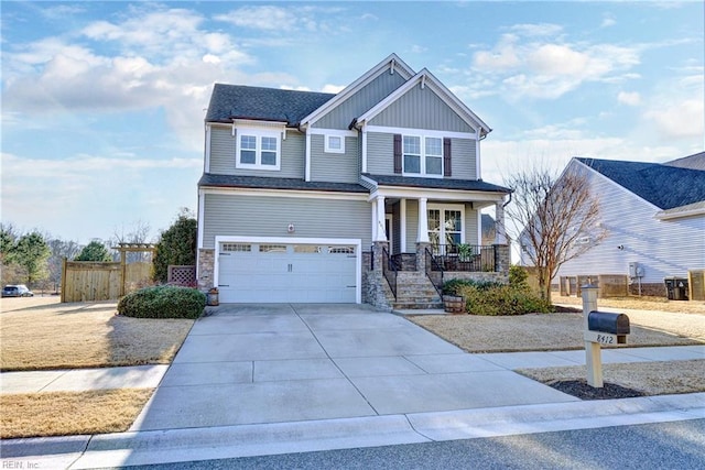 craftsman house featuring a garage, concrete driveway, covered porch, fence, and board and batten siding