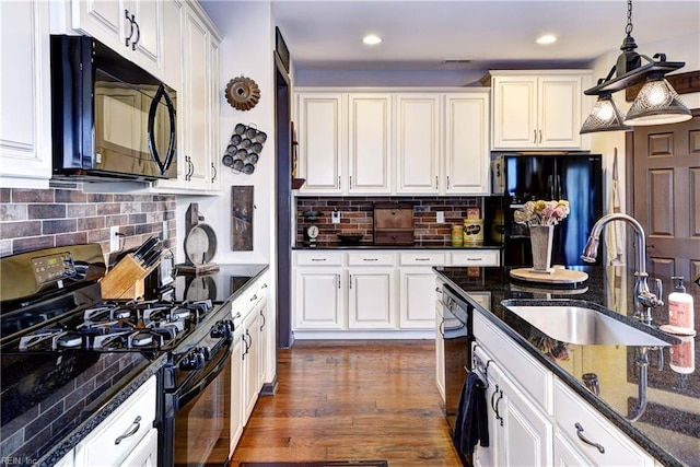 kitchen featuring white cabinets, dark wood-style flooring, black appliances, pendant lighting, and a sink