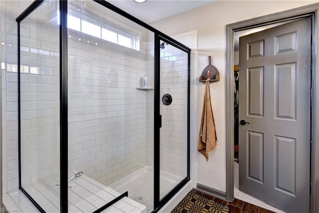 bathroom featuring a stall shower and baseboards