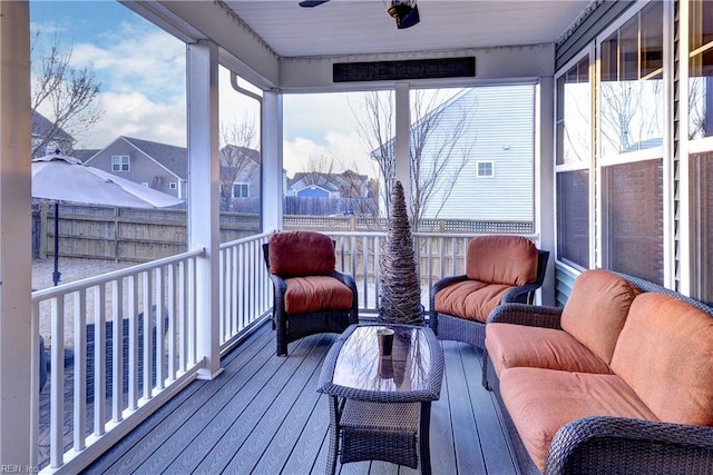 sunroom with a ceiling fan and a residential view