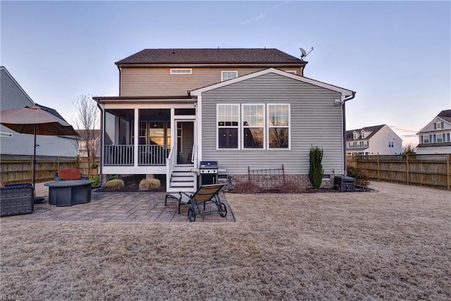 back of house featuring a sunroom, a fenced backyard, and a patio