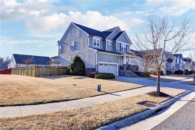 view of front facade featuring a garage, fence, concrete driveway, a residential view, and a front lawn