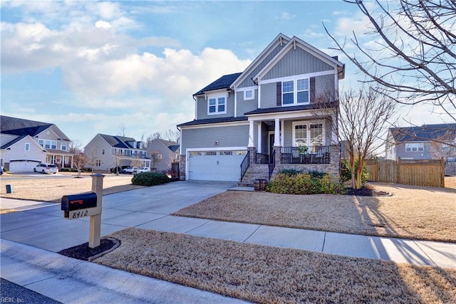 craftsman inspired home with a porch, a garage, concrete driveway, a residential view, and board and batten siding