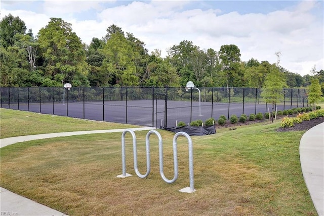 view of sport court featuring community basketball court, fence, and a yard