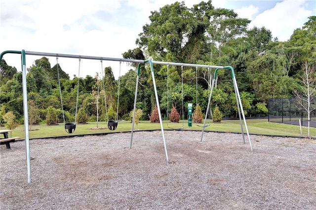 community jungle gym featuring fence and a yard