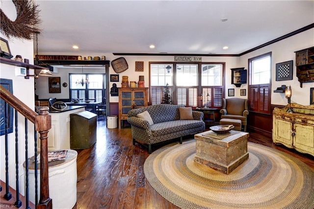 living area with plenty of natural light, stairs, ornamental molding, and wood finished floors