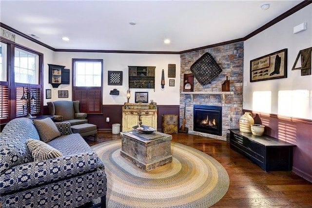 living area featuring a fireplace, wainscoting, wood-type flooring, and crown molding