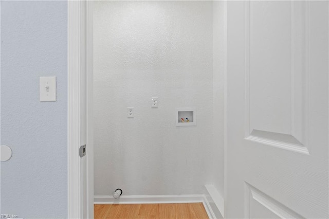 laundry area featuring light wood-type flooring, washer hookup, and baseboards