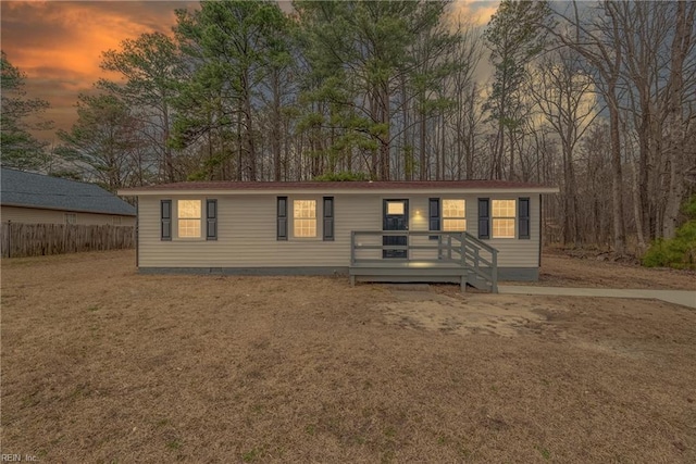 view of front of home featuring crawl space, fence, and a lawn