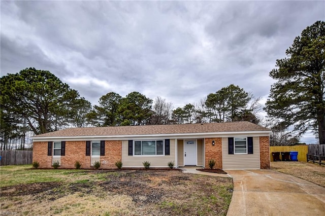 ranch-style house with brick siding, fence, and a front lawn