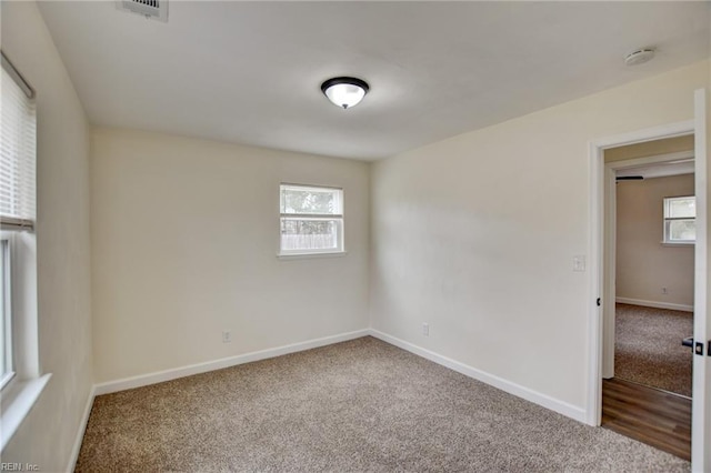 carpeted empty room with visible vents and baseboards